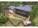 Aerial view showcasing the home's solar panels, spacious backyard, patio, and lush greenery, highlighting its eco-friendly design at 32173 Soda Creek Dr, Evergreen, CO 80439