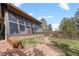 Unique home exterior with large windows and a stone base, surrounded by mature trees and a stone pathway at 32173 Soda Creek Dr, Evergreen, CO 80439