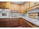Functional kitchen featuring wood cabinets, white appliances, laminate countertops, and ample storage at 32173 Soda Creek Dr, Evergreen, CO 80439
