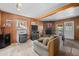 Cozy living room with wood paneled walls, stone fireplace, plush seating, and an exterior door at 32173 Soda Creek Dr, Evergreen, CO 80439