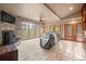 Cozy living room with a stone fireplace, expansive windows with backyard views, and comfortable seating at 32173 Soda Creek Dr, Evergreen, CO 80439