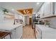 Well-lit kitchen featuring white cabinetry, stainless steel appliances, and a unique wood-framed ceiling light at 1080 E 130Th Ave # A, Thornton, CO 80241