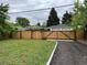 View of the backyard featuring a wooden fence with a gate leading to a gravel driveway at 3210 Newport St, Denver, CO 80207