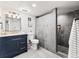 Modern bathroom with a blue vanity, marble shower, and sleek fixtures at 3210 Newport St, Denver, CO 80207