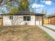 Charming home featuring a stucco exterior, dark accents, and a walkway leading to the front door at 3210 Newport St, Denver, CO 80207