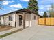 Charming single-story home with a modern entrance and a wooden privacy fence at 3210 Newport St, Denver, CO 80207