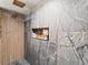 Luxurious shower with marble tile, wood accents, and a built-in niche for storage at 3210 Newport St, Denver, CO 80207