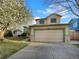 Charming two-story home featuring a lush, blossoming tree and a convenient two-car garage at 4901 Yates Ct, Broomfield, CO 80020