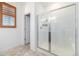 Bathroom featuring tiled walk-in shower with a glass door and window with wood shutters at 3015 Pershing St, Strasburg, CO 80136
