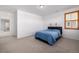 Bedroom featuring a bed with a blue comforter, carpeted floor and window with wooden shutters at 3015 Pershing St, Strasburg, CO 80136