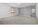 Spacious bedroom features a large window, a gray accent wall, and carpeted floors at 3015 Pershing St, Strasburg, CO 80136
