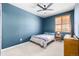 Comfortable blue bedroom with a bed, nightstand, and shuttered window at 3015 Pershing St, Strasburg, CO 80136