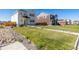 A two-story home showcasing a manicured front lawn and inviting curb appeal under a clear blue sky at 3015 Pershing St, Strasburg, CO 80136