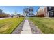 Inviting home with a manicured lawn and walkway, creating a welcoming approach to modern living at 3015 Pershing St, Strasburg, CO 80136