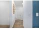 Neutral hallway with wood floors, white walls, and a door to a garage, offers clean transition between spaces at 3015 Pershing St, Strasburg, CO 80136