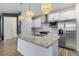 Modern kitchen features stainless appliances, granite countertops, and designer pendant lighting at 3015 Pershing St, Strasburg, CO 80136