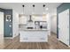 Bright kitchen featuring white cabinets, stainless steel appliances, and a stylish kitchen island at 3015 Pershing St, Strasburg, CO 80136