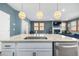 Bright kitchen island features a stainless steel sink and overlooks the open living area at 3015 Pershing St, Strasburg, CO 80136