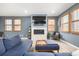 Cozy living room featuring a fireplace, large TV, and comfortable blue seating at 3015 Pershing St, Strasburg, CO 80136