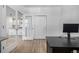 Home office boasts lots of light, a sleek black desk, and a view into the kitchen at 3015 Pershing St, Strasburg, CO 80136