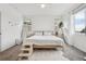 Bright bedroom featuring neutral decor, large windows, ceiling fan, a cozy rug and cat steps to the bed at 17039 E Exposition Dr, Aurora, CO 80017