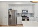 Efficient kitchen with white cabinetry, stainless steel appliances, and a modern gas range at 17039 E Exposition Dr, Aurora, CO 80017