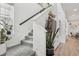 Bright, carpeted staircase with a black handrail and a large houseplant, illuminated by a window at 17039 E Exposition Dr, Aurora, CO 80017