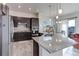 Modern kitchen featuring stainless steel appliances, granite countertops, and dark wood cabinetry at 12668 Ulster St, Thornton, CO 80602
