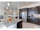 Well-equipped kitchen with stainless steel refrigerator, granite countertops, and modern cabinetry at 12668 Ulster St, Thornton, CO 80602