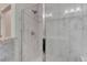 Glass enclosed shower featuring marble-look tiling and silver fixtures at 12668 Ulster St, Thornton, CO 80602