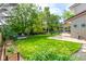 Expansive backyard with lush lawn, manicured gardens, and a charming patio area at 3720 S Willow Cir, Denver, CO 80237