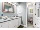 Charming bathroom featuring a classic vanity, framed mirror, and tiled floors at 3720 S Willow Cir, Denver, CO 80237