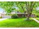 Charming brick home with a lush green lawn and mature trees at 3720 S Willow Cir, Denver, CO 80237