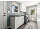 Bright laundry room with white cabinets, stainless steel washer/dryer, and exterior access door at 3720 S Willow Cir, Denver, CO 80237