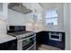 Modern kitchen featuring stainless steel appliances, white subway tile backsplash, and black and white cabinets at 1732 Stable View Dr, Castle Pines, CO 80108