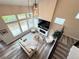 Bright living room boasts soaring ceilings, hardwood floors, large windows, and fireplace for cozy ambiance at 1732 Stable View Dr, Castle Pines, CO 80108