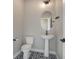 Stylish powder room with unique blue tile floor and modern pedestal sink at 1732 Stable View Dr, Castle Pines, CO 80108