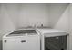 Bright laundry room featuring a modern front load washer and dryer appliances at 3522 W 17Th Ave, Denver, CO 80204