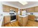 Kitchen features wood cabinets, island, and built-in desk at 1524 E Weldona Way, Superior, CO 80027