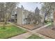 Charming condo building featuring private balconies, a well-maintained lawn, and a stone landscape at 5300 E Cherry Creek South Dr # 217, Denver, CO 80246