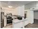 Efficient kitchen features white cabinets, modern stainless steel appliances, and contrasting black and white backsplash at 5300 E Cherry Creek South Dr # 217, Denver, CO 80246