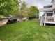 Large, fenced backyard with a grassy lawn, deck, and mature trees at 12196 Helena St, Commerce City, CO 80603