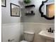 Stylish half-bathroom with a white vanity, decorative mirror, and floating shelves for added storage and elegance at 12196 Helena St, Commerce City, CO 80603