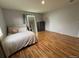 Neutral bedroom with natural light, hardwood floors, and large decorative mirror at 12196 Helena St, Commerce City, CO 80603