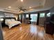 Spacious main bedroom featuring hardwood floors, tray ceilings, a ceiling fan, and large windows allowing for ample natural light at 12196 Helena St, Commerce City, CO 80603