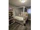 Bedroom featuring a four post bed, a shelf for displaying items, and wood look flooring at 1051 Jasper St, Aurora, CO 80011