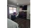 Bedroom with a desk, dresser with TV, dark wood floors, and natural light from the windows at 1051 Jasper St, Aurora, CO 80011