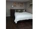 Comfortable bedroom with dark wood floors, neutral walls, and a classic bed with green and gray pillows at 1051 Jasper St, Aurora, CO 80011