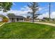 Street view of home with a large front lawn, mature trees, driveway, and covered parking at 7752 Meade St, Westminster, CO 80030
