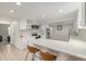 Bright, modern kitchen boasts an island with seating, stainless steel appliances, and white cabinets at 7752 Meade St, Westminster, CO 80030